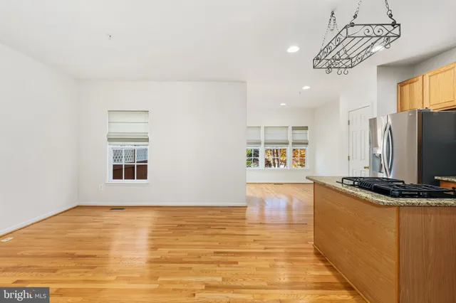 a kitchen with stainless steel appliances granite countertop a sink a stove top oven a counter space and cabinets