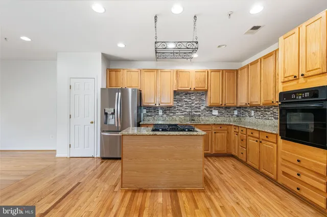 a kitchen with stainless steel appliances granite countertop a stove and cabinets