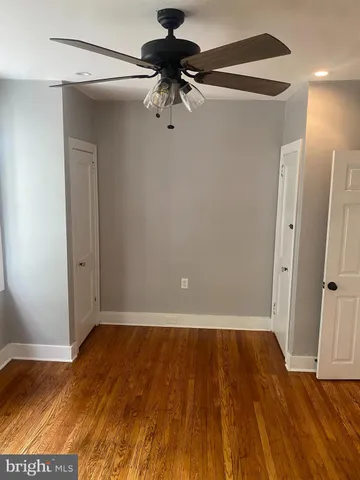 a view of room with hardwood floor and ceiling fan