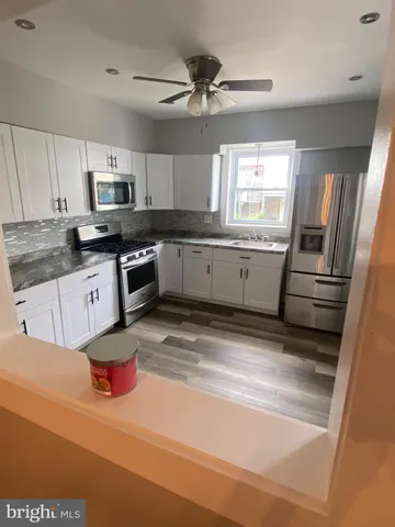 a kitchen with granite countertop a sink stainless steel appliances and cabinets