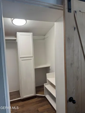 a view of a room with wooden floor and cabinet