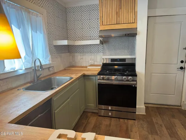 a kitchen with granite countertop a stove and a sink