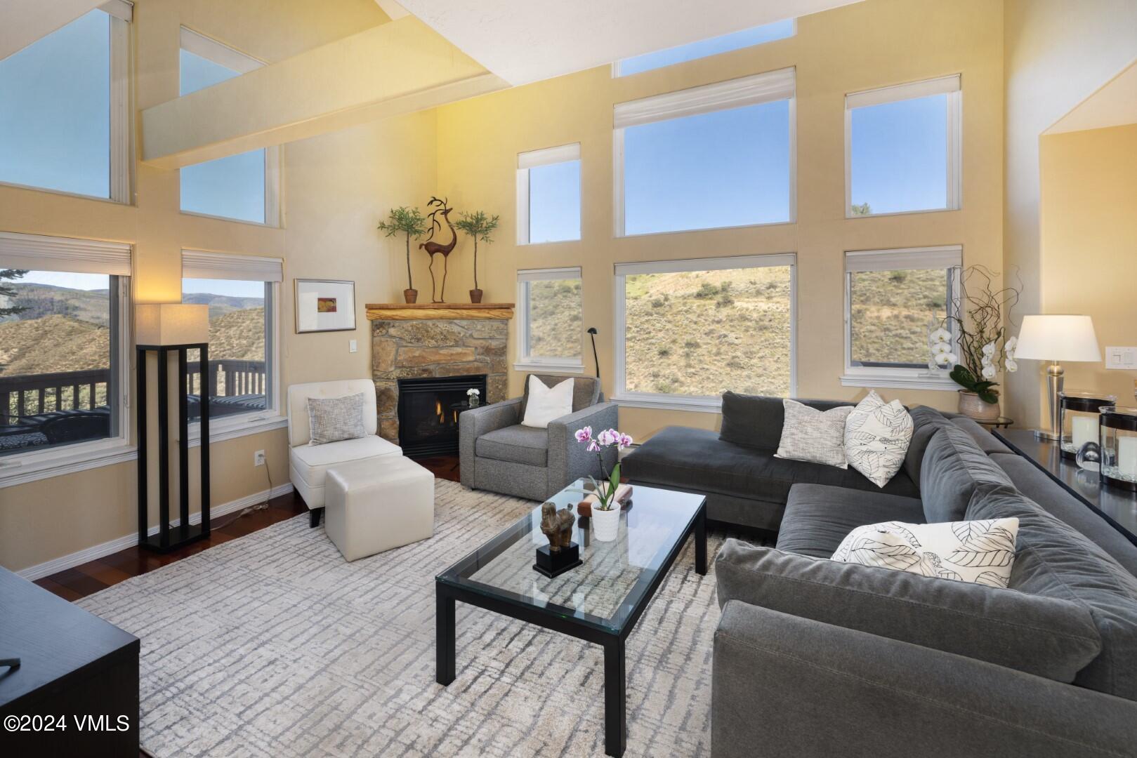 a living room with furniture a fireplace and a large window
