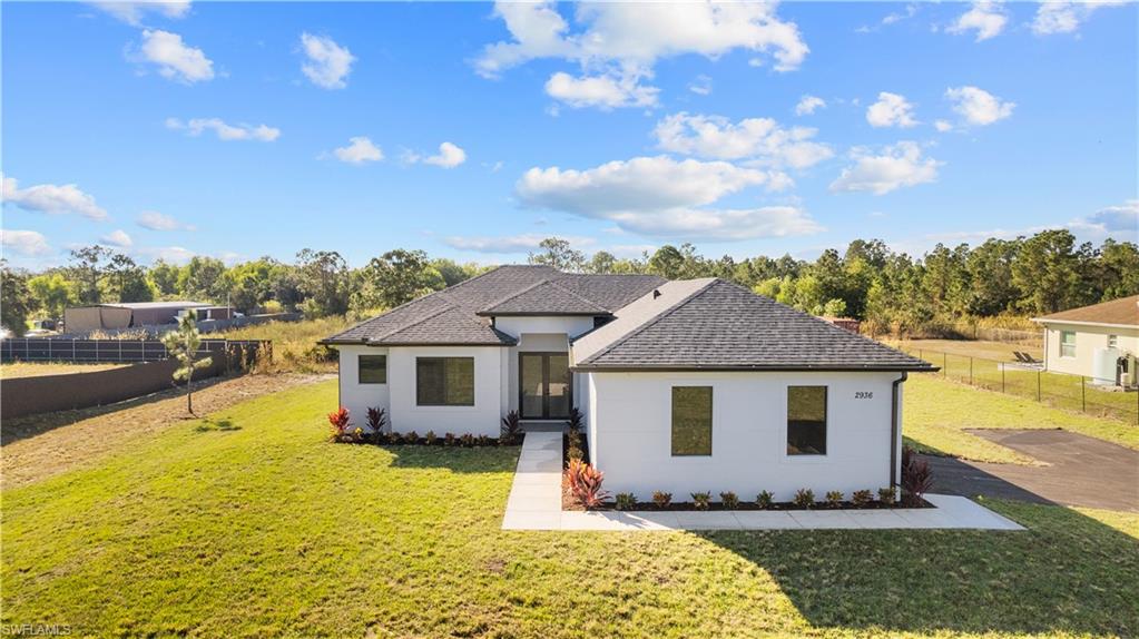 a front view of house with yard and lake view in back