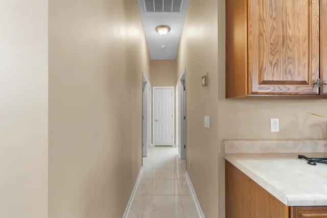 a view of a hallway with wooden cabinets