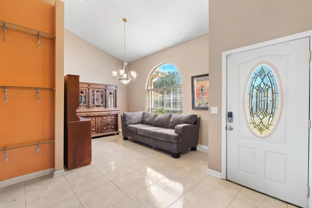 a living room with furniture a chandelier and a window