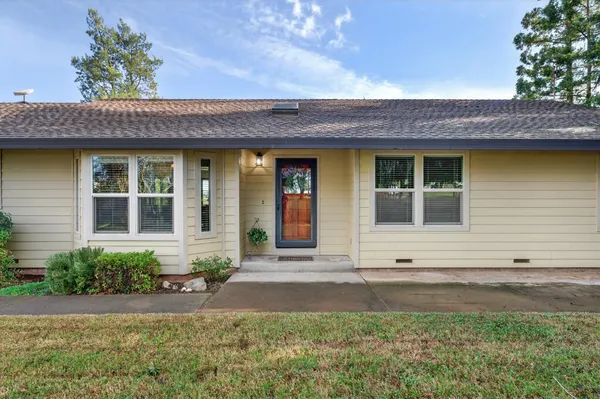 front view of a brick house with a yard