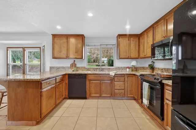 a kitchen with stainless steel appliances granite countertop a stove sink and cabinets