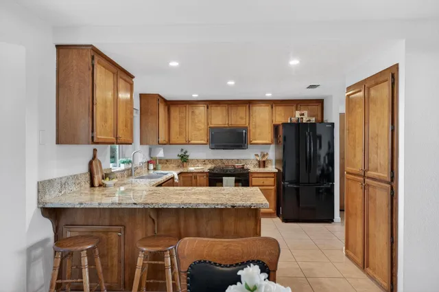 a kitchen with granite countertop a refrigerator and a sink
