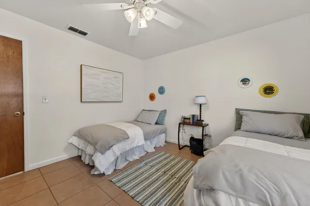 a spacious bedroom with a bed and a potted plant