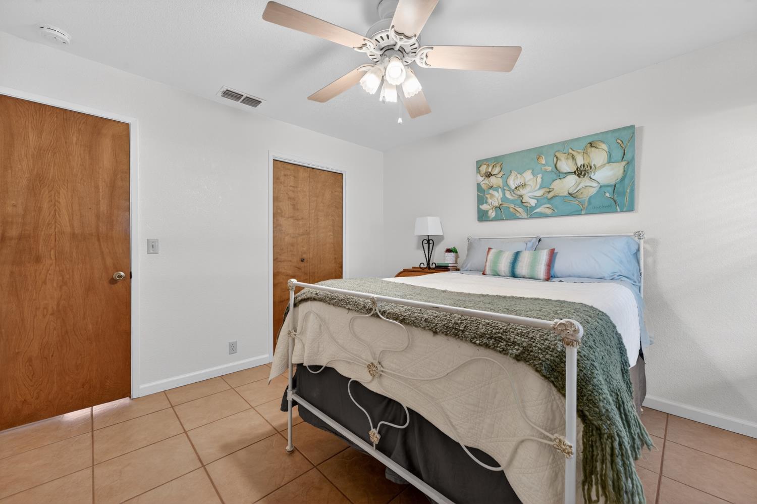 10919 Alta Mesa Road Wilton, CA 95693 - Photo 26 of 66 a spacious bedroom with a bed and a chandelier