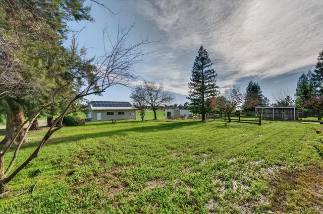 a view of a house with a big yard and a fountain