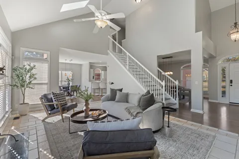 a living room with furniture potted plant and a ceiling fan