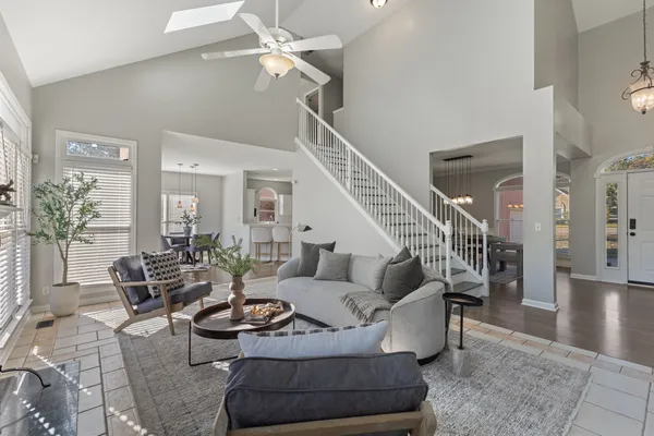 a living room with furniture potted plant and a ceiling fan