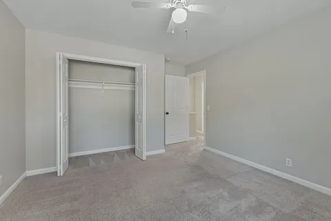 an empty room with a chandelier fan