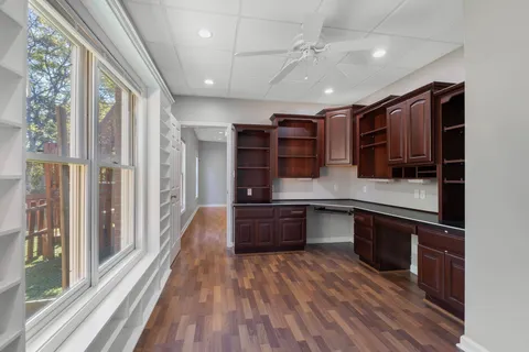 a large kitchen with stainless steel appliances granite countertop plenty wooden cabinets counter space and a window
