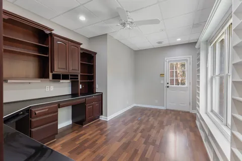 an empty room with wooden floor and cabinet