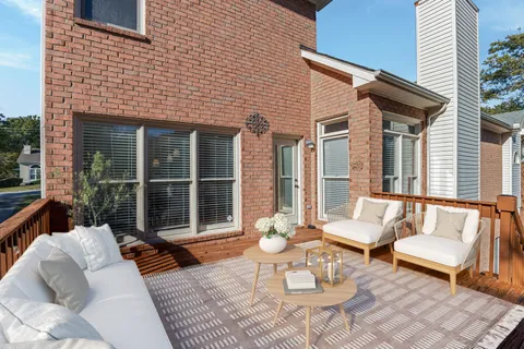 a view of a patio with couches table and chairs and potted plants