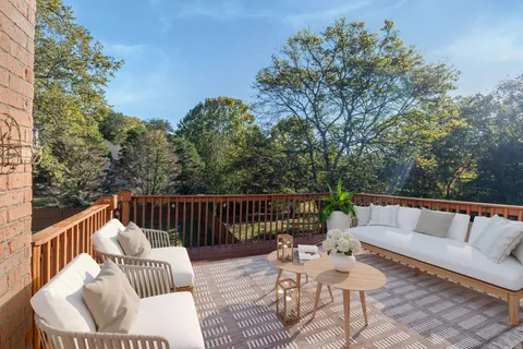 a balcony with wooden floor and outdoor seating