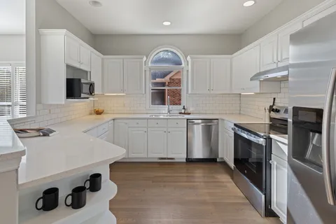 a kitchen with a sink a stove top oven and cabinets