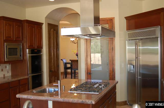 12815 Silver Wolf Road Reno, NV 89511 - Photo 4 of 9 a kitchen with stainless steel appliances granite countertop a refrigerator and a stove