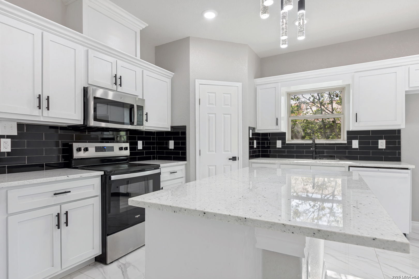 237 Avenue D Poteet, TX 78065 - Photo 13 of 27 a kitchen with stainless steel appliances granite countertop a stove a sink and a microwave