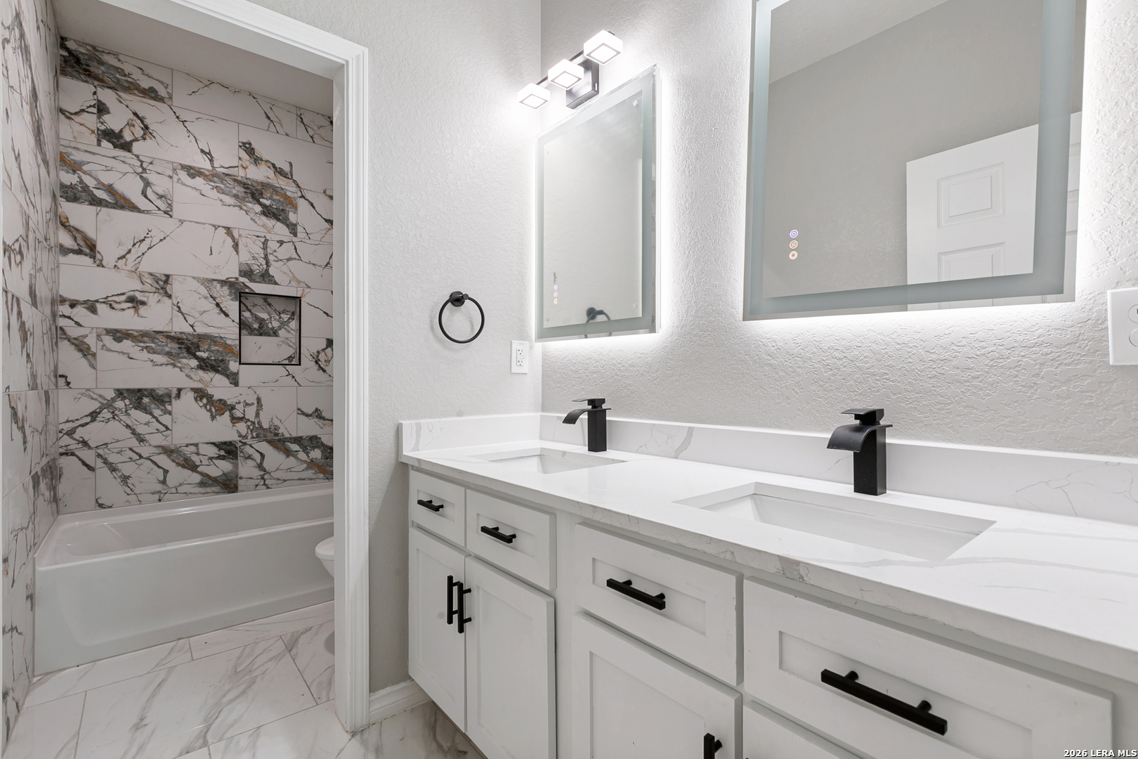 237 Avenue D Poteet, TX 78065 - Photo 20 of 27 a bathroom with a granite countertop sink a toilet a mirror and shower