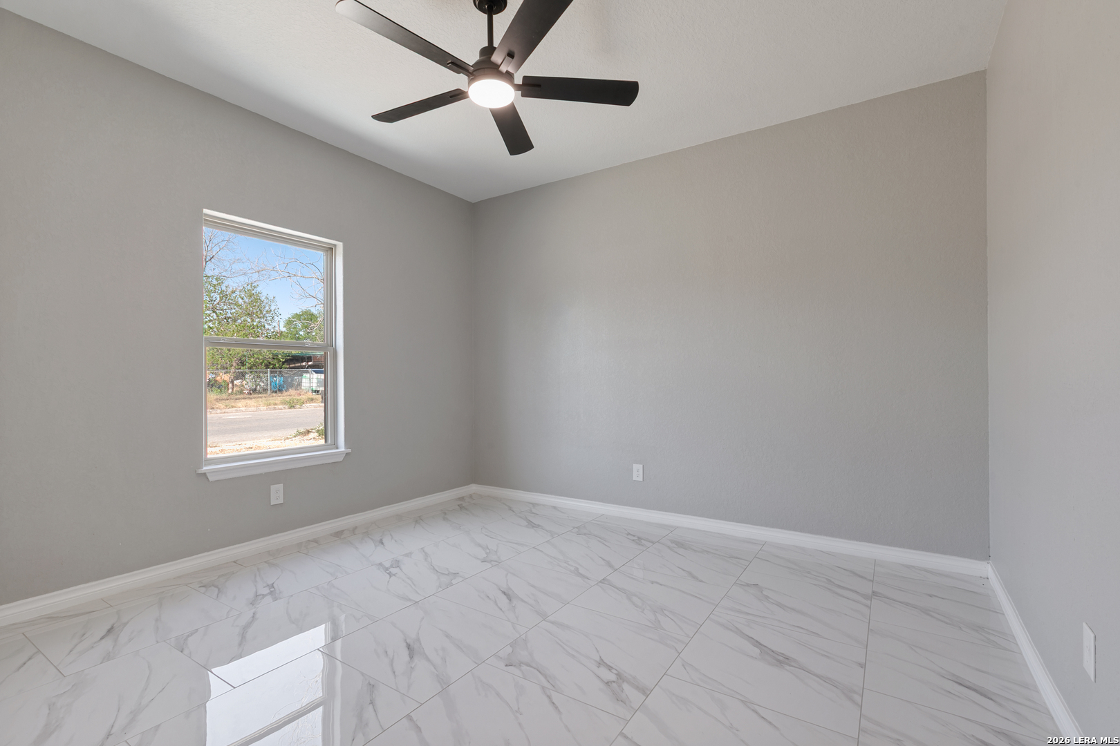 237 Avenue D Poteet, TX 78065 - Photo 24 of 27 an empty room with a window and a fan