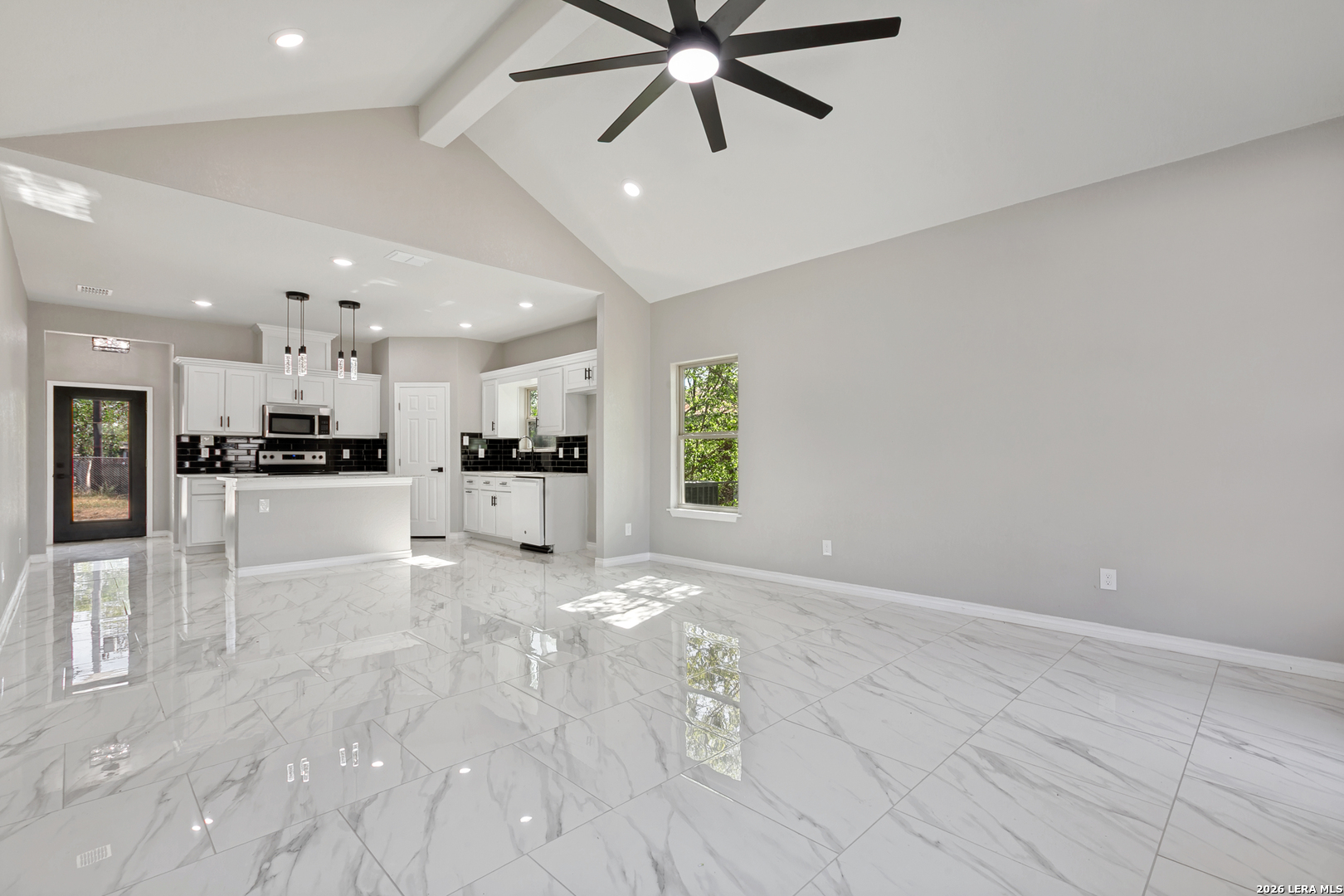 237 Avenue D Poteet, TX 78065 - Photo 7 of 27 a view of a kitchen with kitchen island a counter top space appliances and a ceiling fan