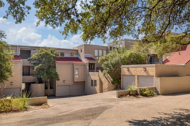a view of a house with a yard and large tree