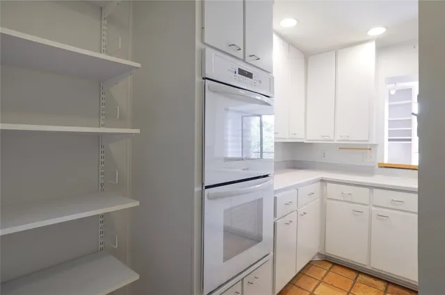 a kitchen with white cabinets and white appliances
