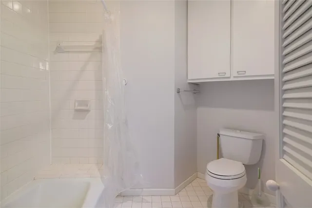 a white toilet sitting next to a bath tub