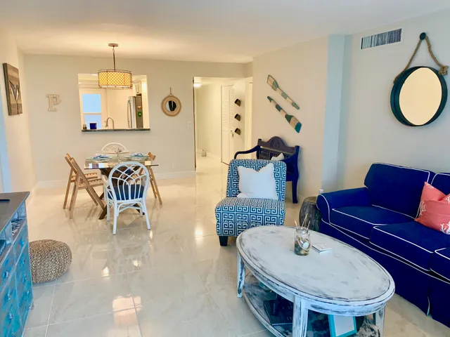 a living room with furniture a mirror and a table