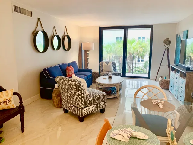 a living room with furniture and a floor to ceiling window
