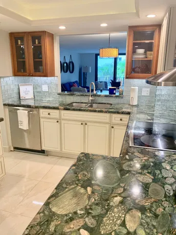 a kitchen with granite countertop a sink and a stove