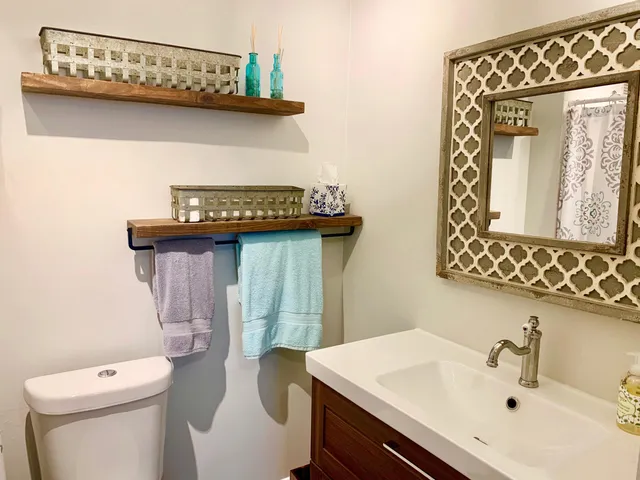 a bathroom with a toilet a sink and mirror