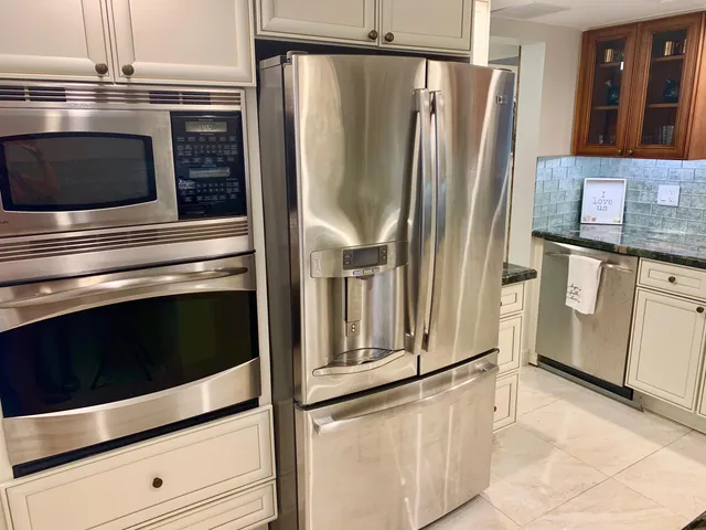 a kitchen with granite countertop white cabinets and stainless steel appliances