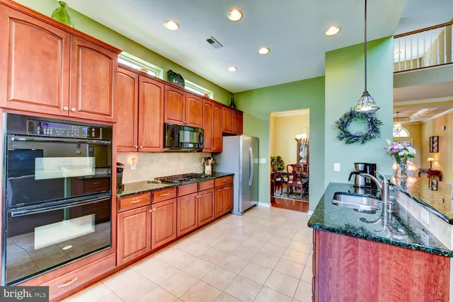 a kitchen with stainless steel appliances granite countertop a stove a sink and a refrigerator