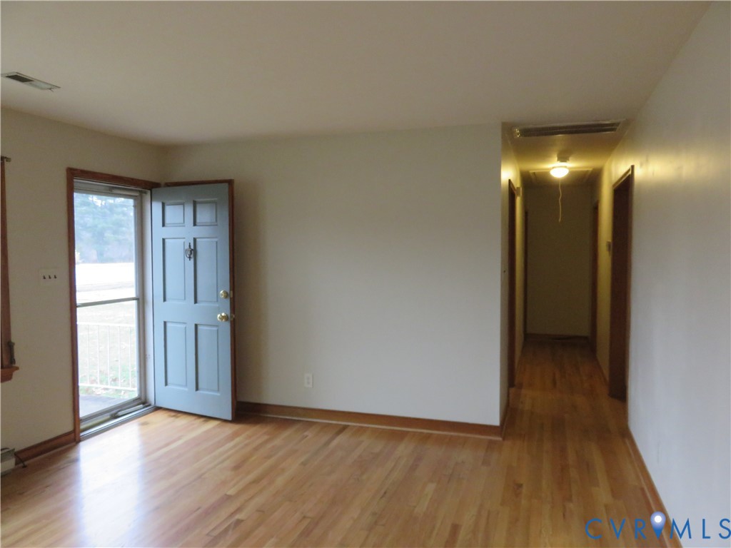 6729 Cold Harbor Road Mechanicsville, VA 23111 - Photo 2 of 22 a view of an empty room with wooden floor and a window