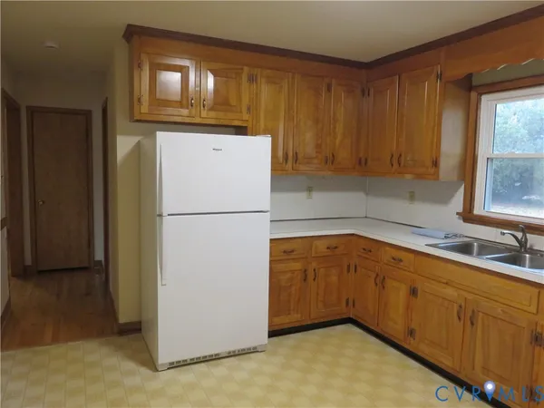 a kitchen with sink refrigerator and cabinets