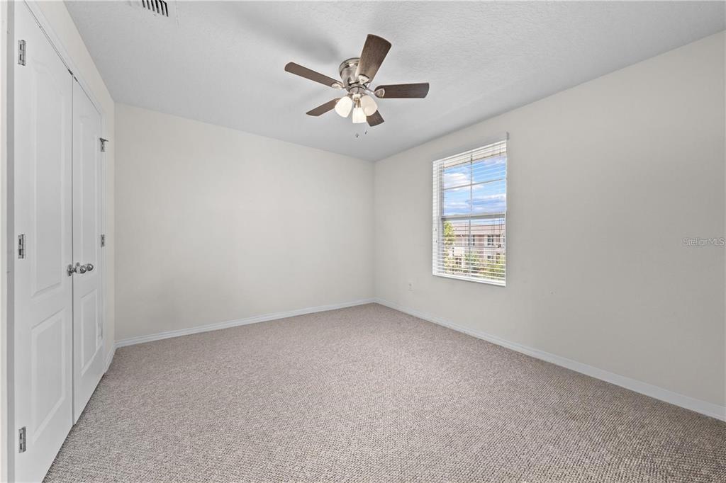 1619 Reflection Cove St. Cloud, FL 34771 - Photo 12 of 54 an empty room with ceiling fan and windows
