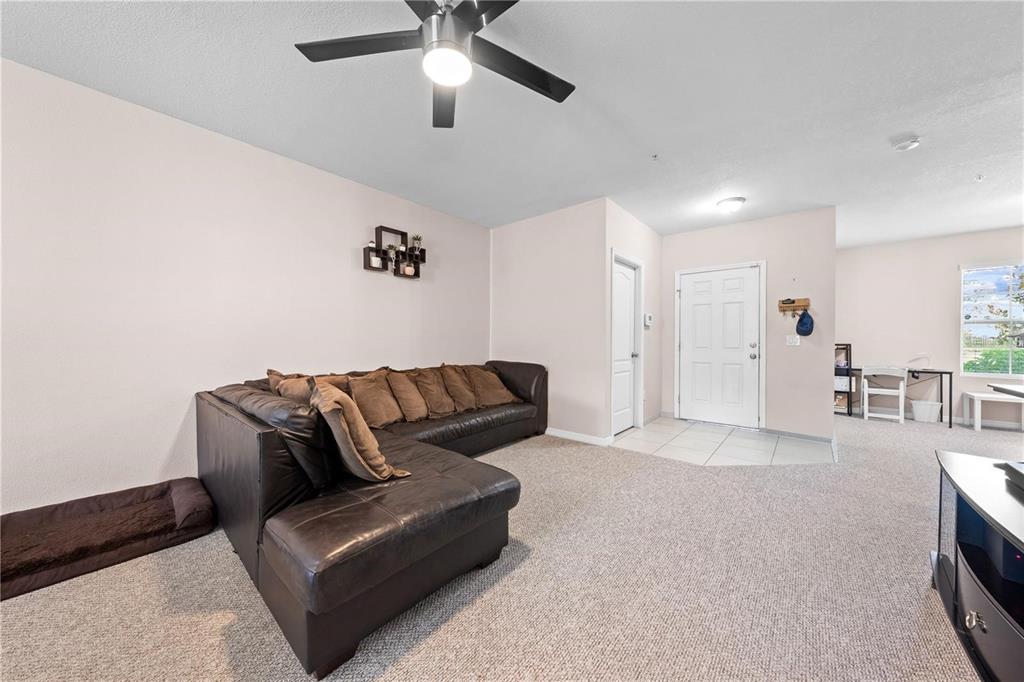 1619 Reflection Cove St. Cloud, FL 34771 - Photo 14 of 54 a living room with furniture and a chandelier