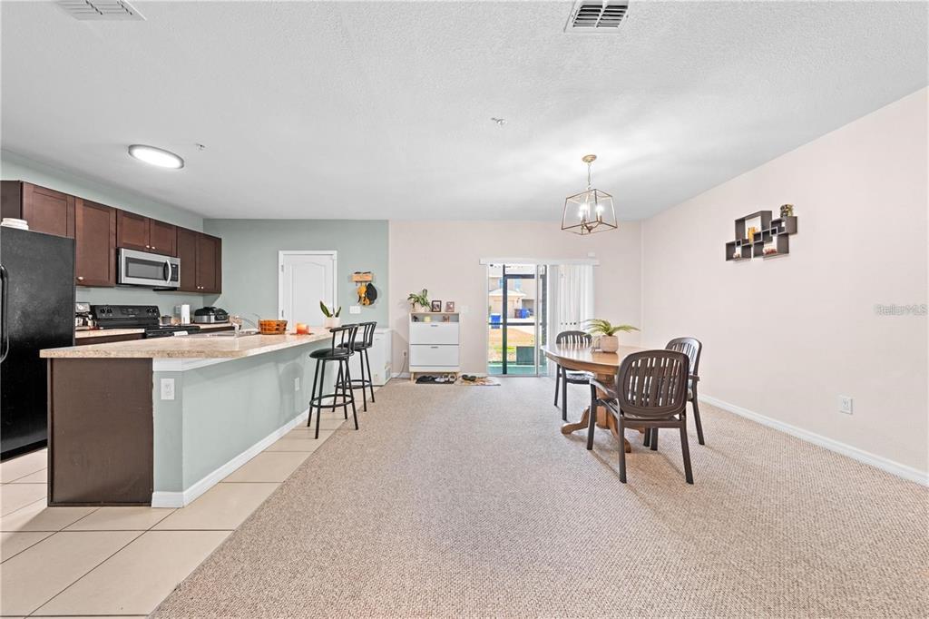 1619 Reflection Cove St. Cloud, FL 34771 - Photo 16 of 54 a living room with furniture a dining table and kitchen view