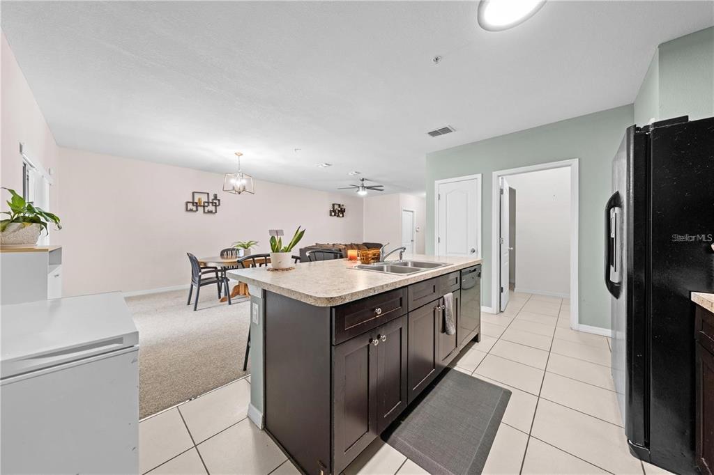 1619 Reflection Cove St. Cloud, FL 34771 - Photo 17 of 54 a kitchen with stainless steel appliances granite countertop a kitchen island a stove a refrigerator and a sink