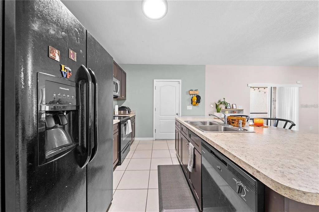 1619 Reflection Cove St. Cloud, FL 34771 - Photo 18 of 54 a kitchen with stainless steel appliances granite countertop a refrigerator a stove and a sink