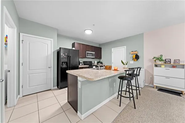 a kitchen with stainless steel appliances kitchen island granite countertop a refrigerator and a stove top oven