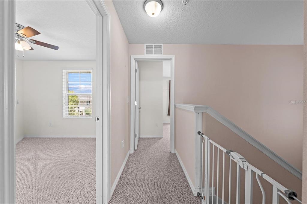 1619 Reflection Cove St. Cloud, FL 34771 - Photo 22 of 54 a view of a hallway with wooden floor and a bathroom