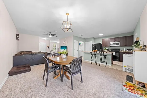 a view of a dining room with furniture and a view of kitchen