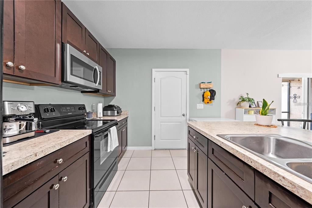 1619 Reflection Cove St. Cloud, FL 34771 - Photo 7 of 54 a kitchen with stainless steel appliances granite countertop a sink stove and cabinets
