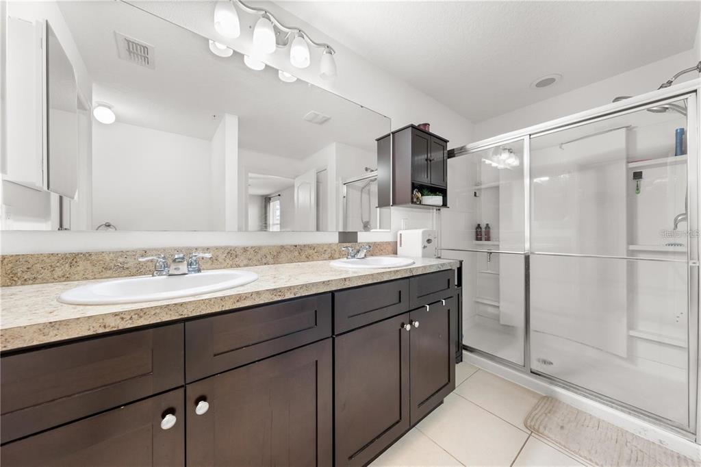1619 Reflection Cove St. Cloud, FL 34771 - Photo 10 of 54 a bathroom with a sink double vanity and a shower